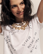 Veronica Beard White short-sleeve t-shirt with black text graphics on the back, paired with dark wash flare jeans.