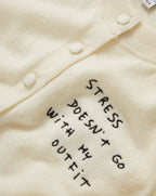 Veronica Beard Cream knit cardigan with "STRESS DOESN'T GO WITH MY OUTFIT" embroidered in black.
