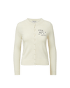 Veronica Beard Cream knit cardigan with "Stress doesn't go with my outfit" embroidered on the chest.