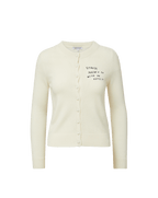Veronica Beard Cream knit cardigan with "Stress doesn't go with my outfit" embroidered on the chest.
