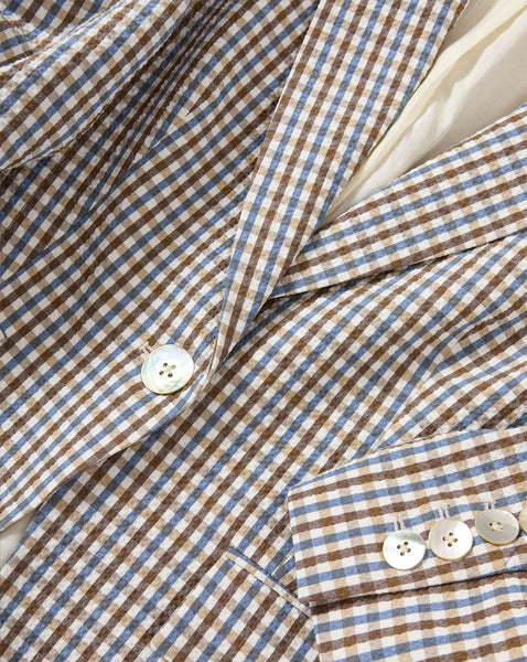 The image depicts a close-up view of a plaid or checkered fabric pattern, with a white button visible in the foreground.