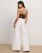 Veronica Beard Black floral print camisole and white wide-leg jeans.