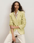 Veronica Beard Light green double-breasted blazer with peak lapels, paired with a white button-down shirt and off-white trousers.