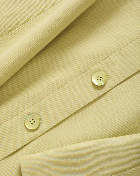 The image shows a close-up view of a beige fabric material with two white buttons visible on the surface.