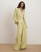 Veronica Beard Light green double-breasted blazer with wide-leg pleated trousers and a lace camisole.