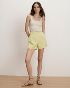 Veronica Beard Ribbed knit tank top in off-white and pleated high-waisted shorts in light yellow.