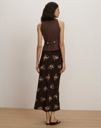 Veronica Beard Brown sleeveless vest with silver buttons and a black floral midi skirt.