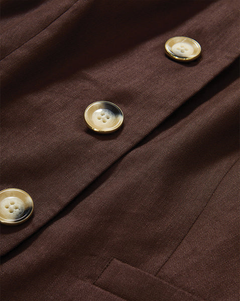 The image shows a close-up view of several white buttons on a dark brown fabric, creating a textured and visually interesting composition.
