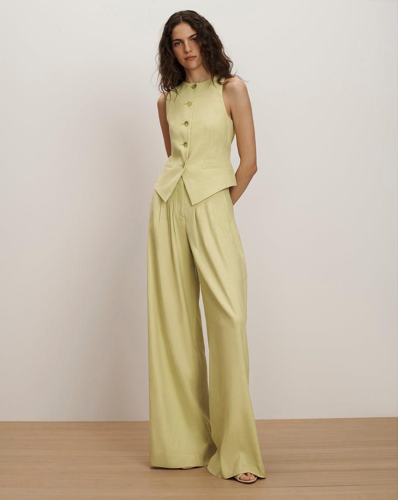 Veronica Beard Light green vest with wide-leg pleated trousers and a lace camisole.