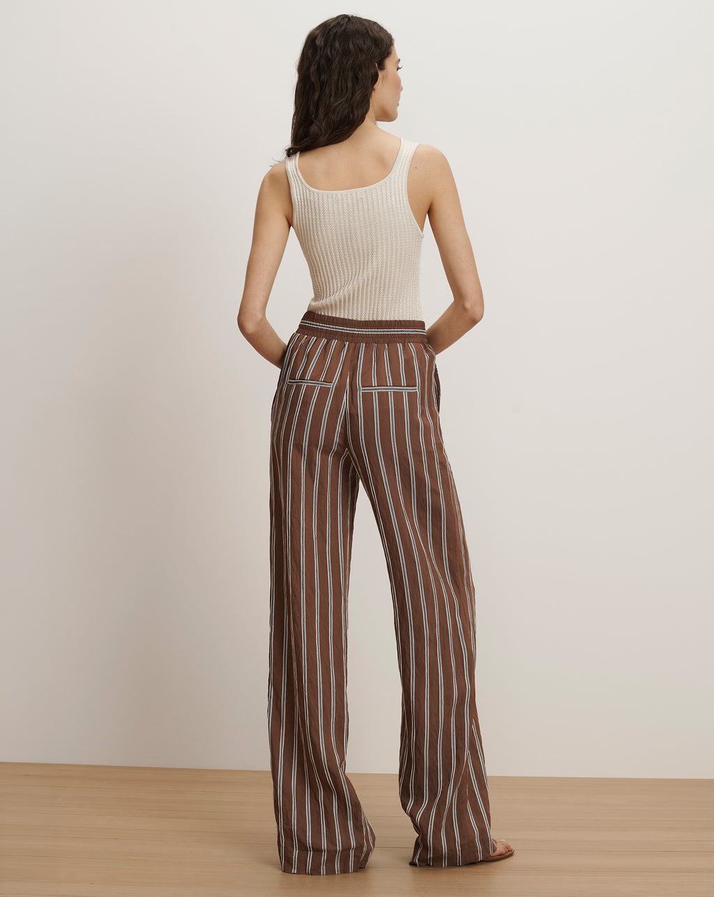 Veronica Beard Ribbed cream tank top and brown and white striped wide-leg pants.