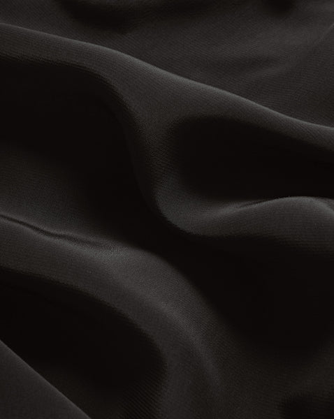 Veronica Beard Black fabric with soft folds and subtle sheen.