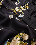 Veronica Beard Black floral dress with ruched bodice and tie detail.