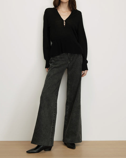 Veronica Beard Black knit collared sweater, dark wash wide-leg jeans.