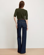 Veronica Beard Dark green short-sleeve sweater and dark wash flare jeans.