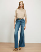 Veronica Beard Beige short-sleeve knit top and wide-leg blue jeans.