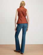 Veronica Beard Brown sleeveless blazer and blue flare jeans.
