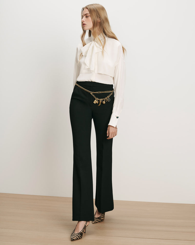 Veronica Beard White silk pussy-bow blouse and black flared trousers.