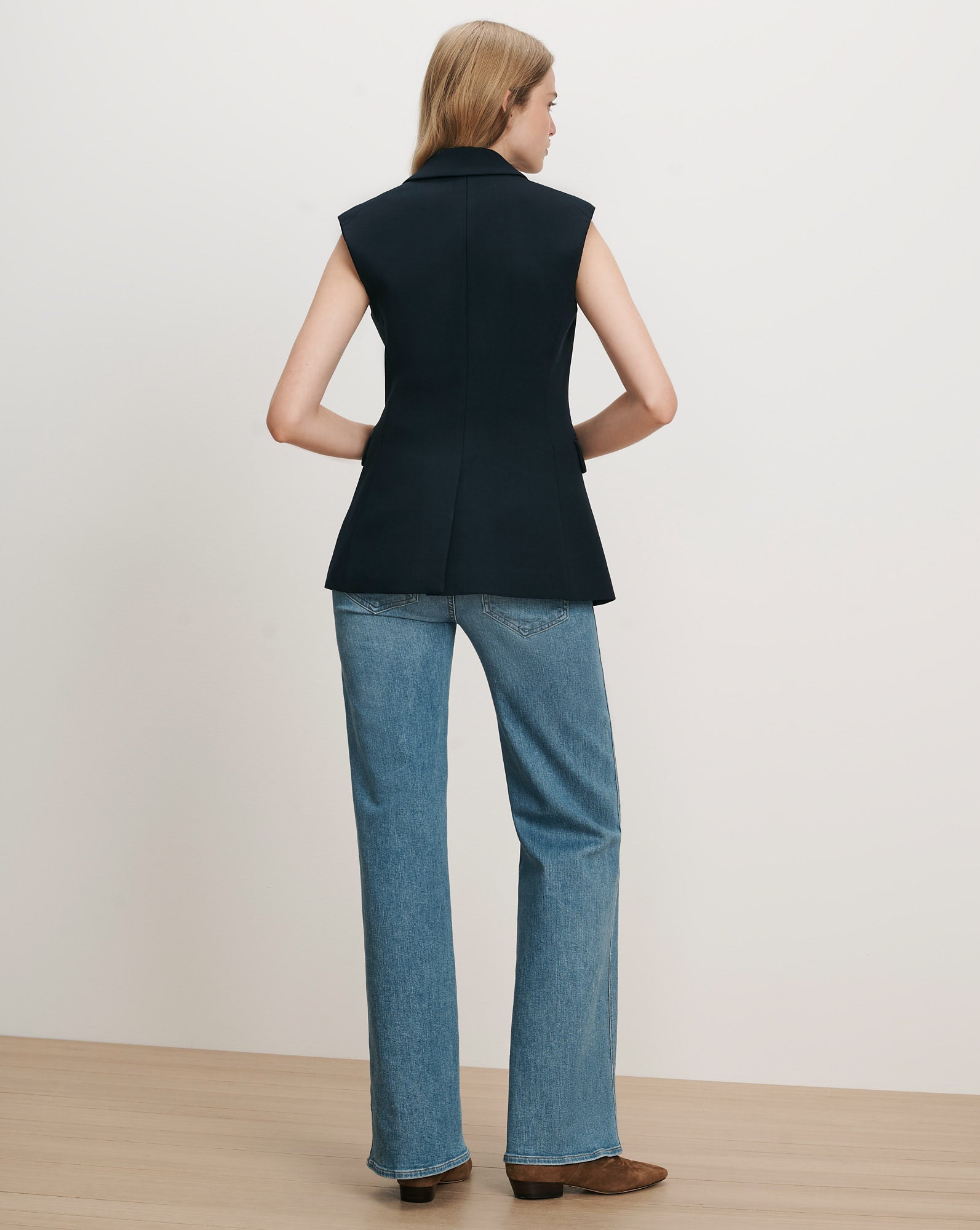 Veronica Beard Navy sleeveless blazer, wide-leg jeans.