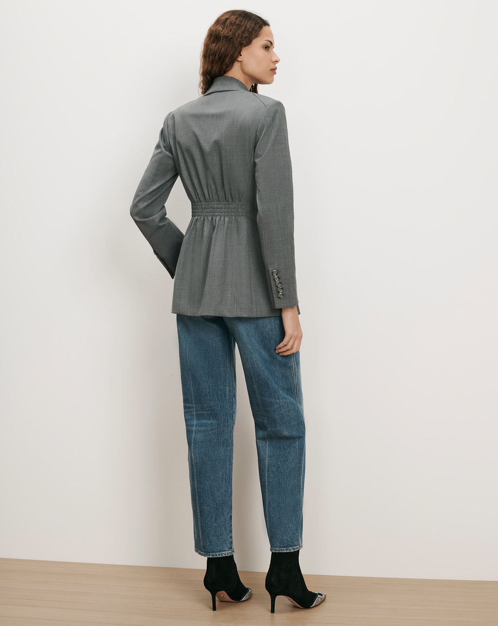 Veronica Beard Gray blazer with cinched waist and blue jeans.