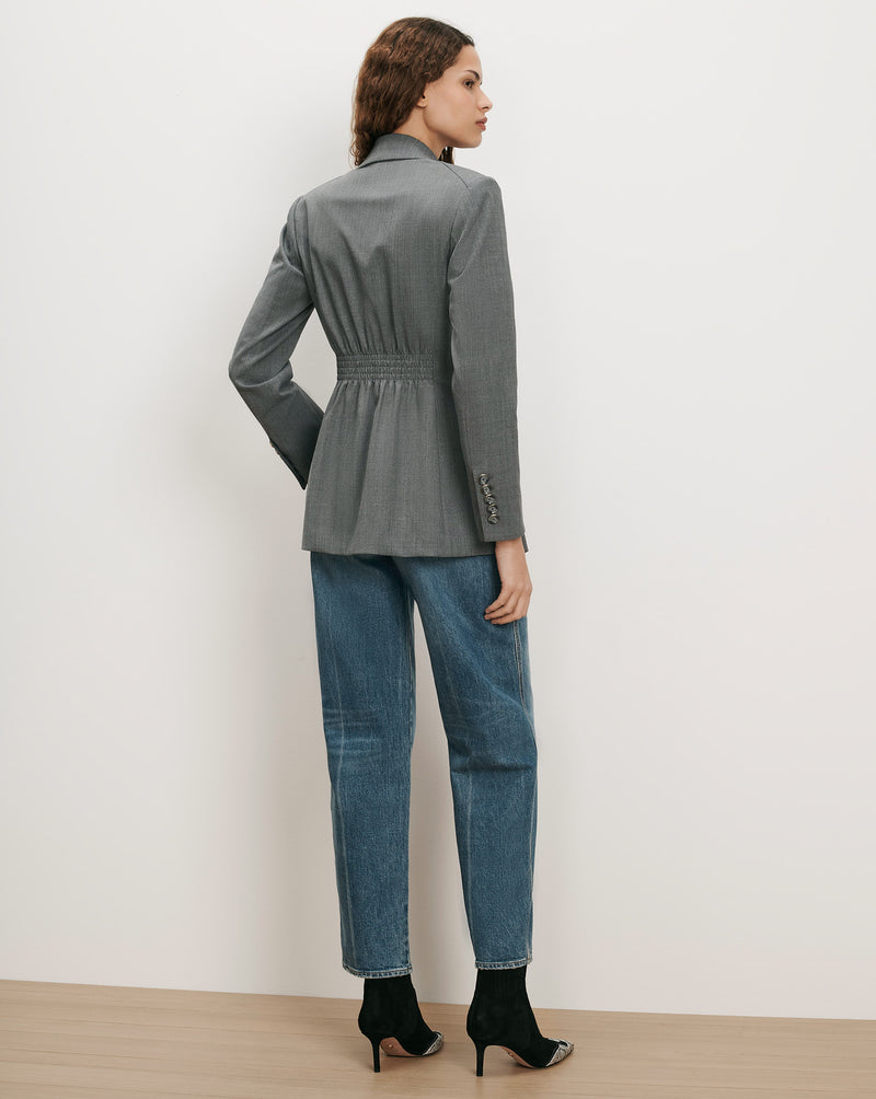 Veronica Beard Gray blazer with cinched waist and blue jeans.