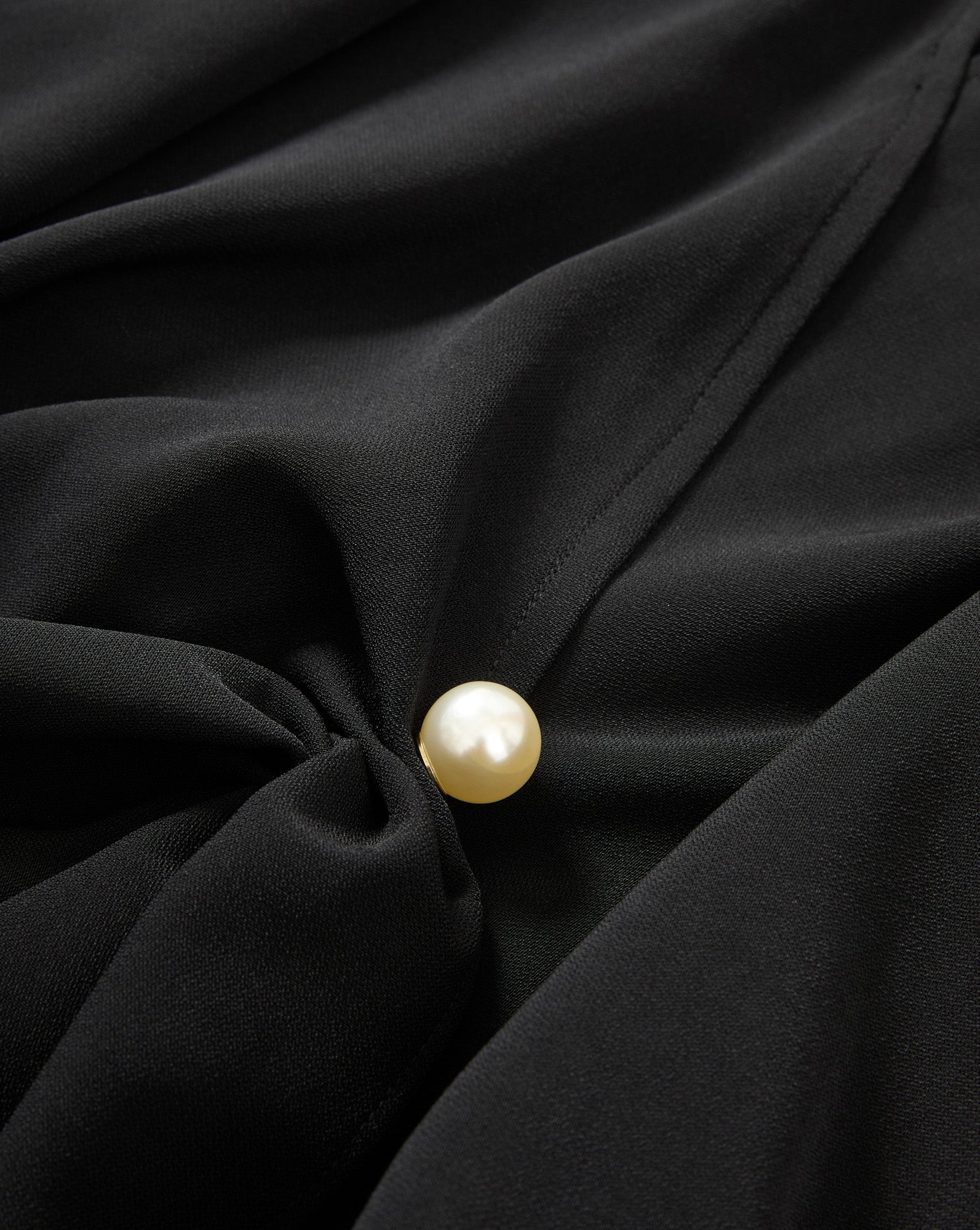 Veronica Beard Black blouse with a pearl button.