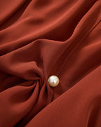 Veronica Beard Rust blouse, draped, with a pearl button.