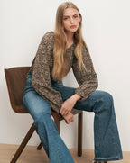 Veronica Beard Brown floral blouse, blue flared jeans.