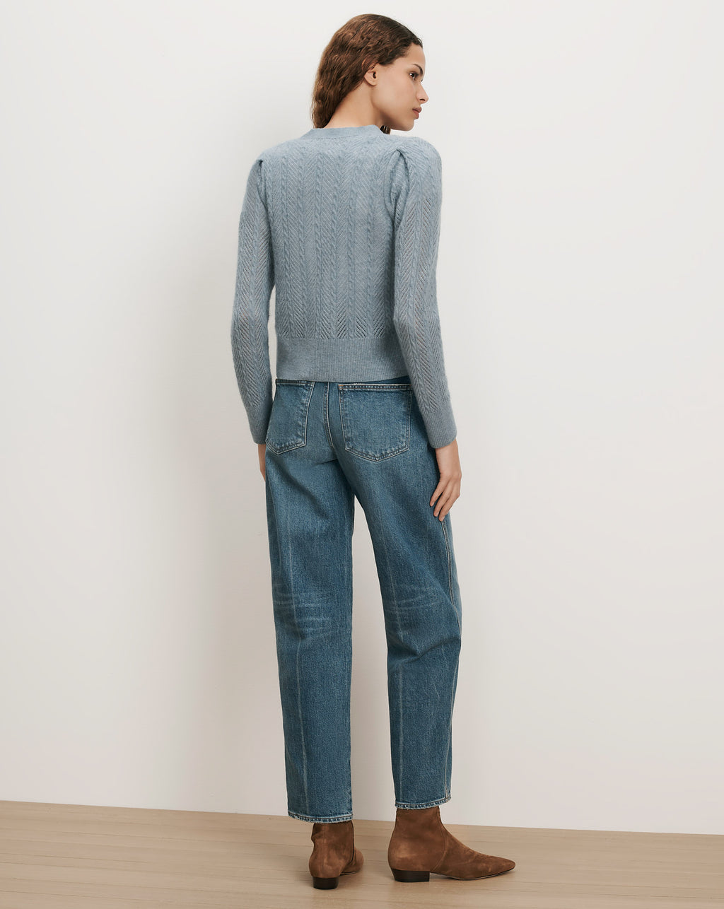 Veronica Beard Blue cable knit sweater, puff sleeves, and straight-leg jeans.