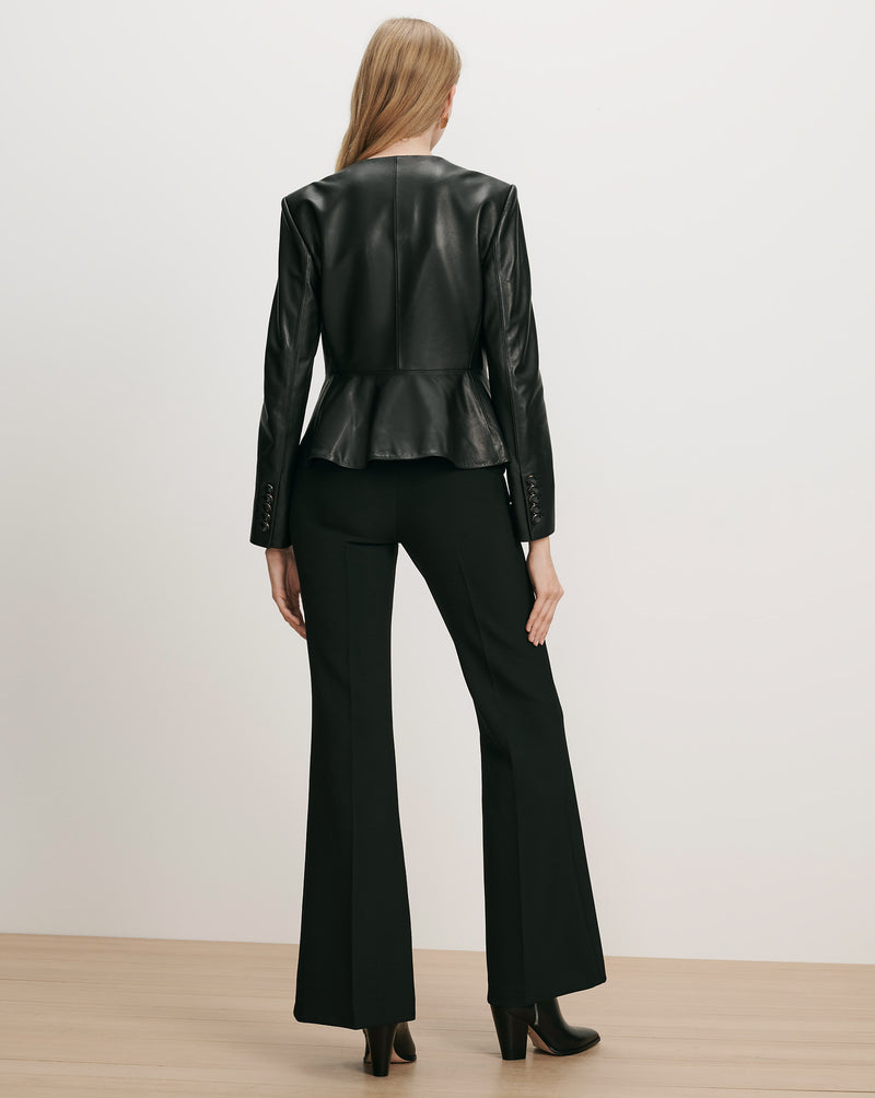 Veronica Beard Black leather peplum jacket and black flared trousers.