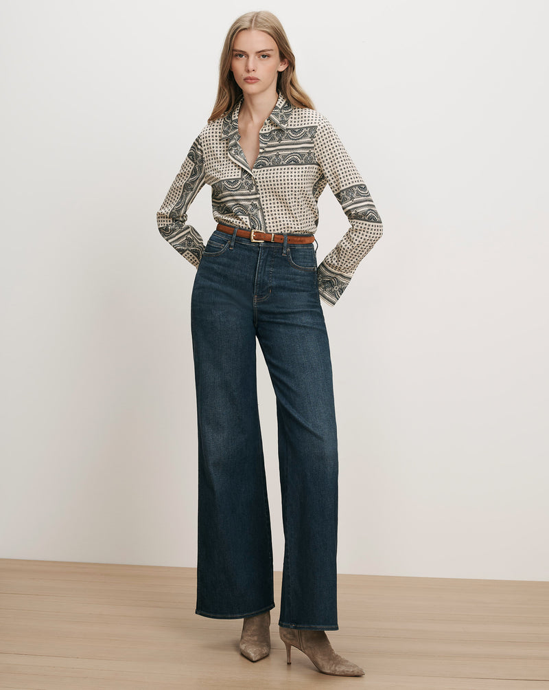 Veronica Beard Printed silk shirt, dark wash wide-leg jeans, brown belt.
