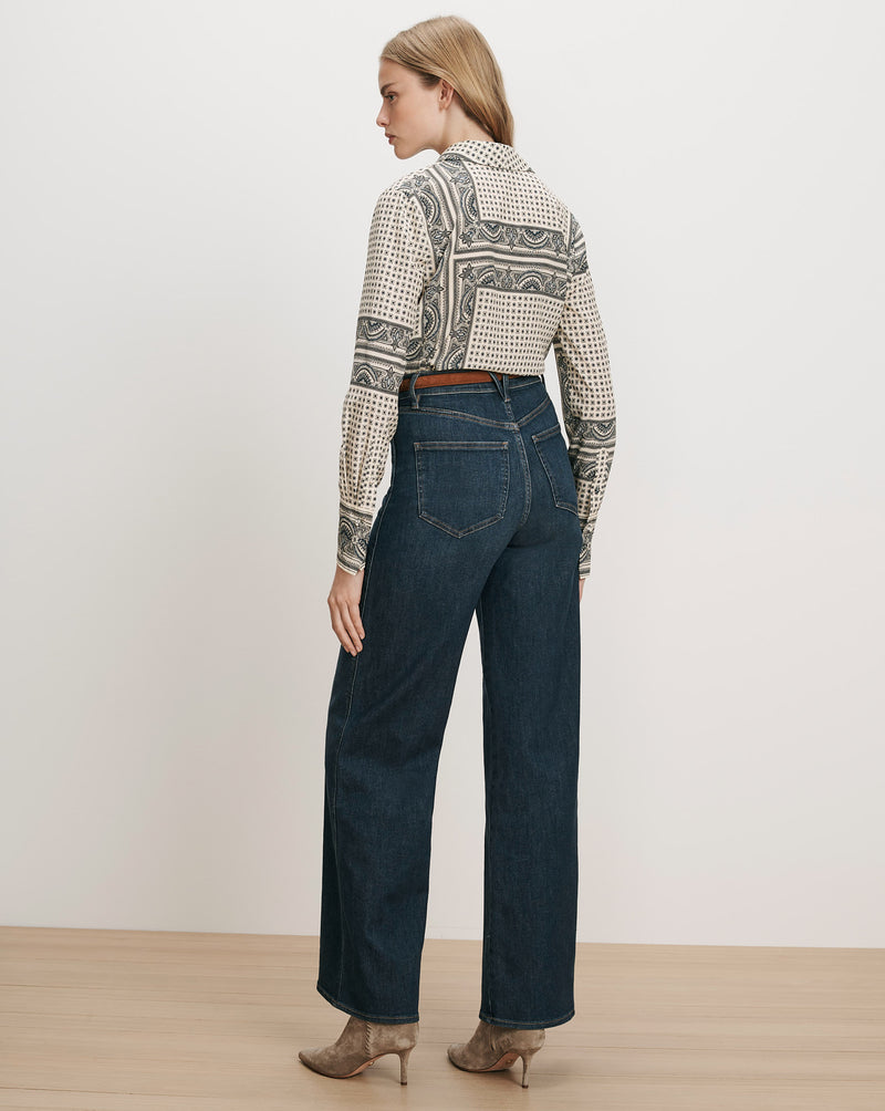 Veronica Beard White patterned silk shirt, dark wash wide-leg jeans.