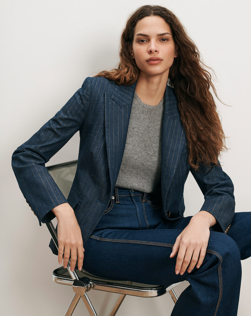 Veronica Beard Blue pinstripe blazer, gray sweater, and dark wash jeans.