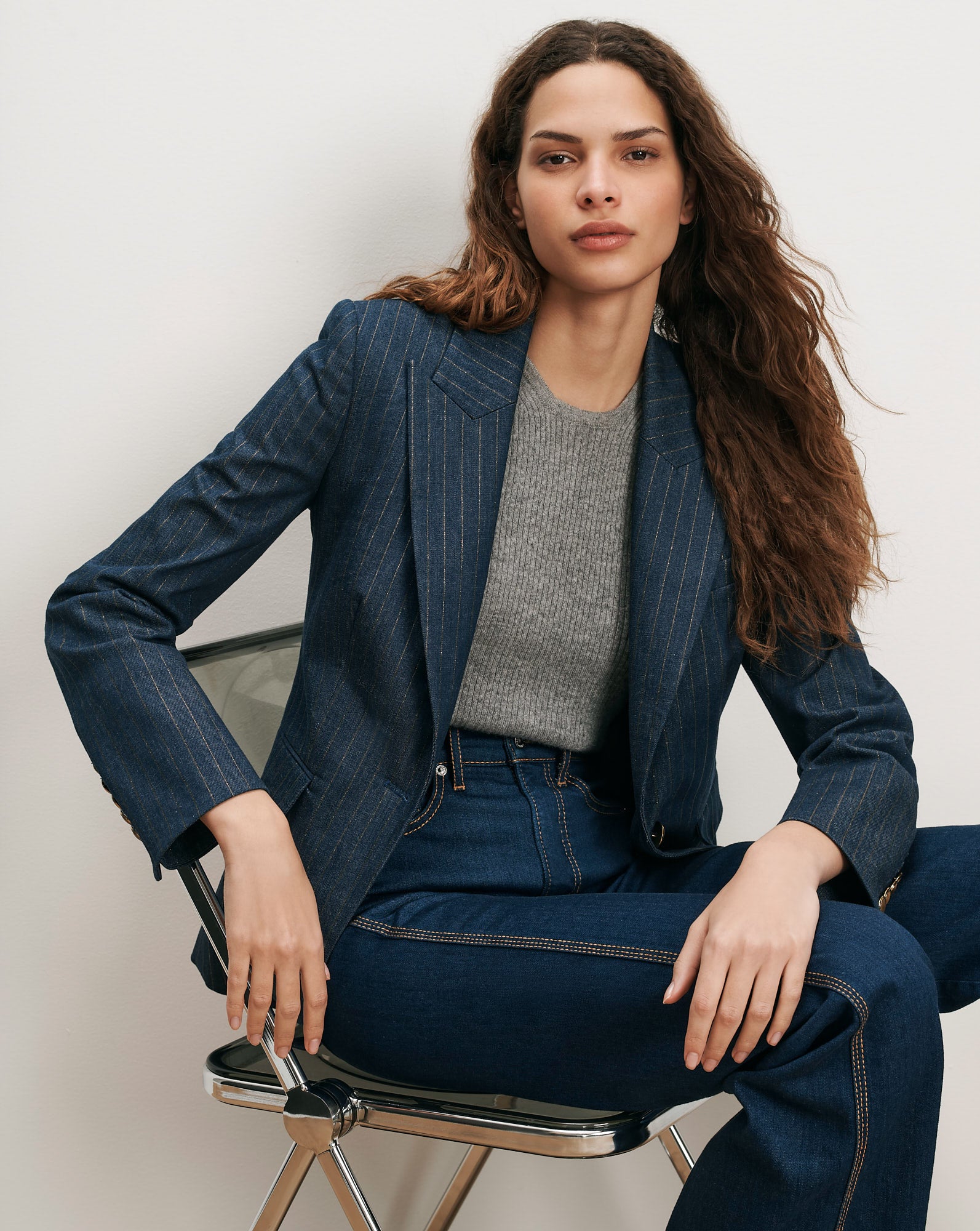 Veronica Beard Blue pinstripe blazer, gray sweater, and dark wash jeans.