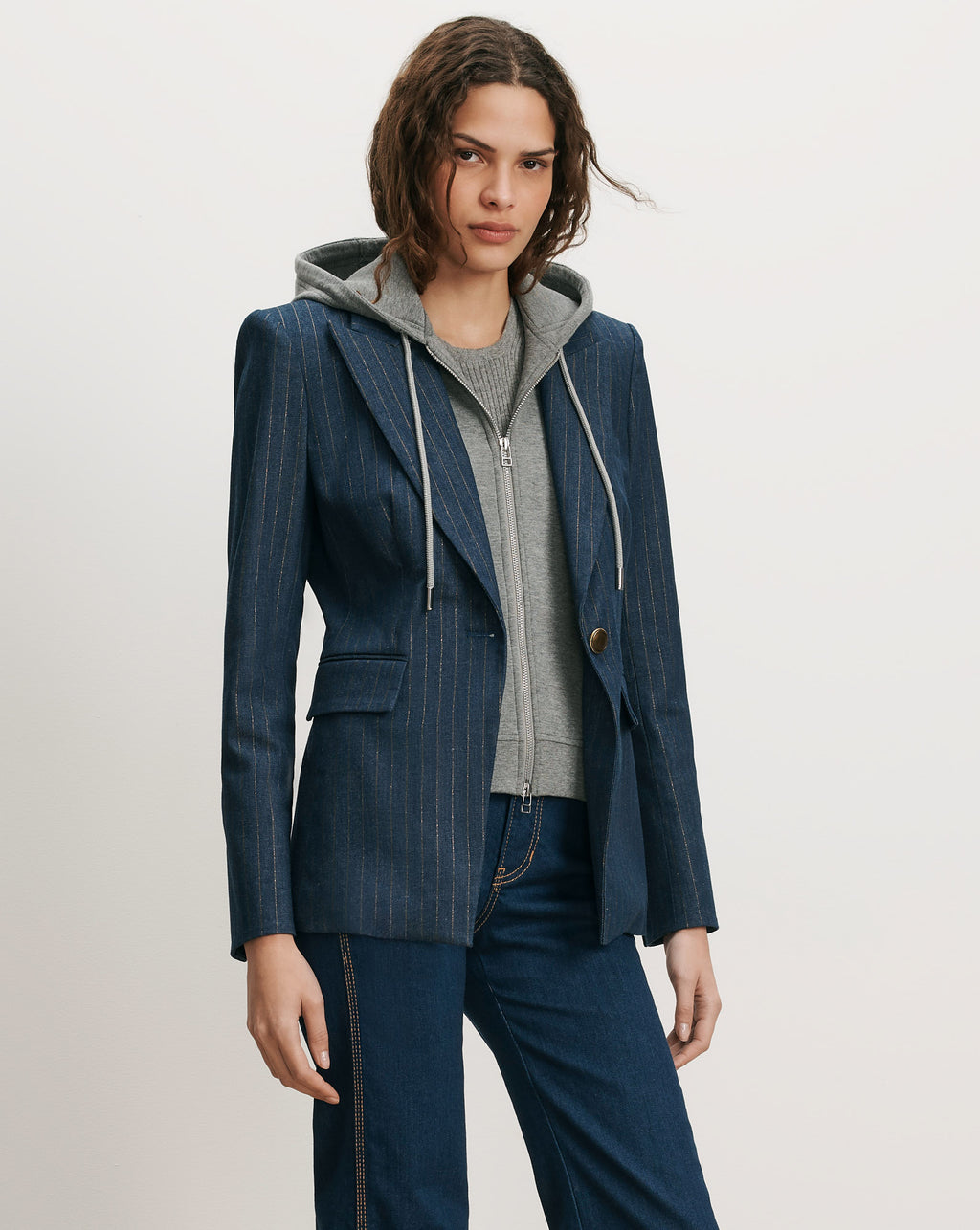 Veronica Beard Blue pinstripe blazer over gray hooded sweatshirt.