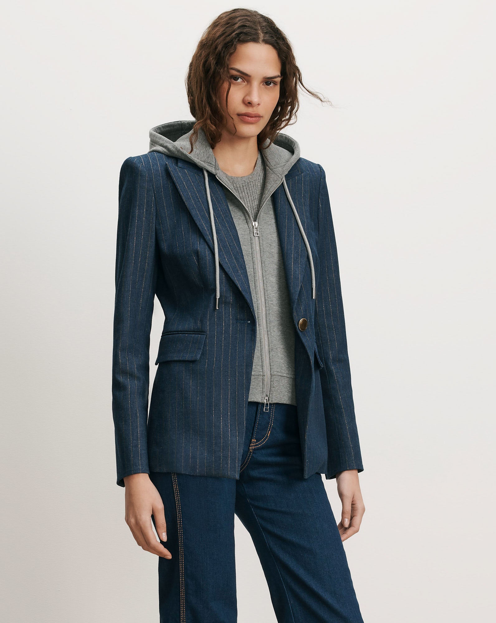 Veronica Beard Blue pinstripe blazer over gray hooded sweatshirt.