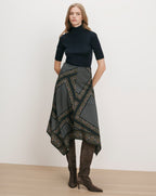 Veronica Beard Black ribbed turtleneck, patterned handkerchief hem skirt, brown suede boots.