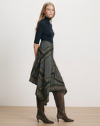 Veronica Beard Black turtleneck, patterned handkerchief skirt, brown suede boots.