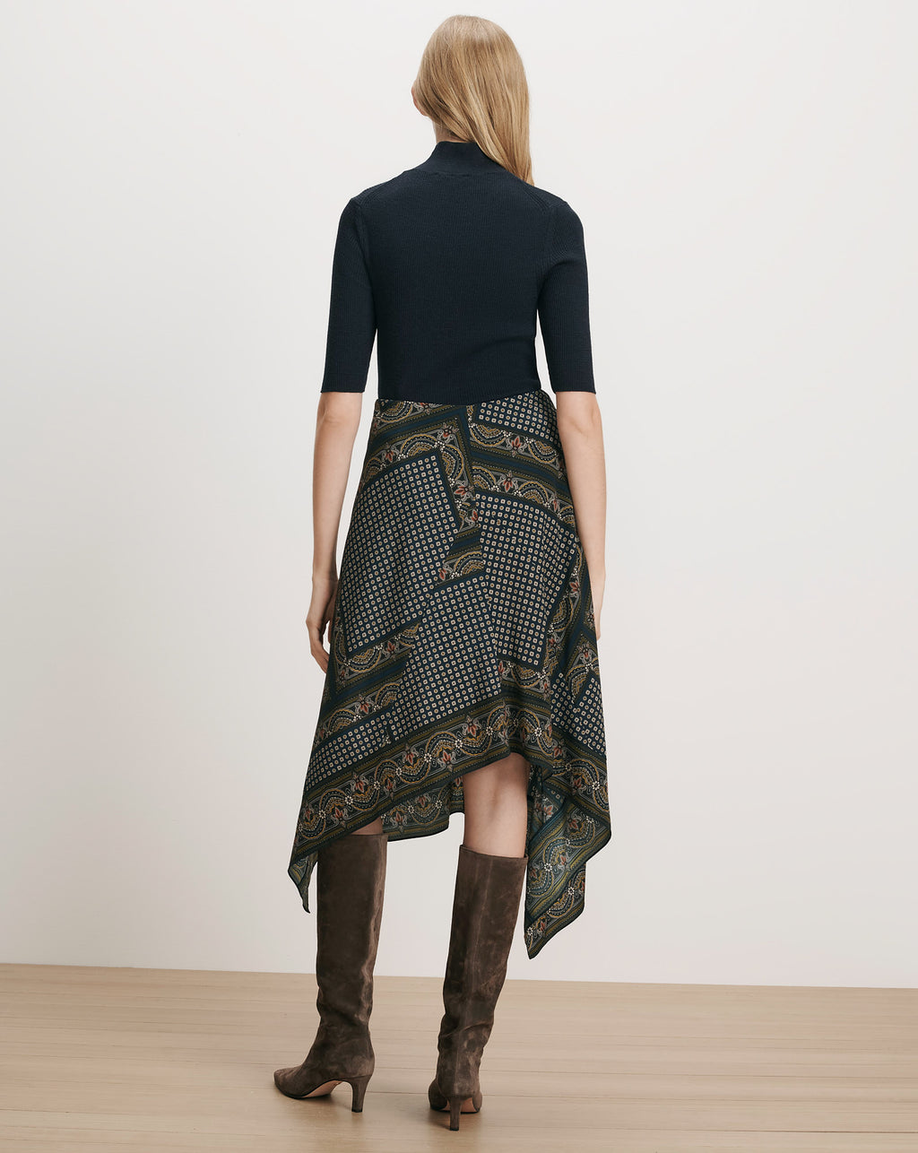 Veronica Beard Black ribbed top, patterned handkerchief skirt, brown suede boots.
