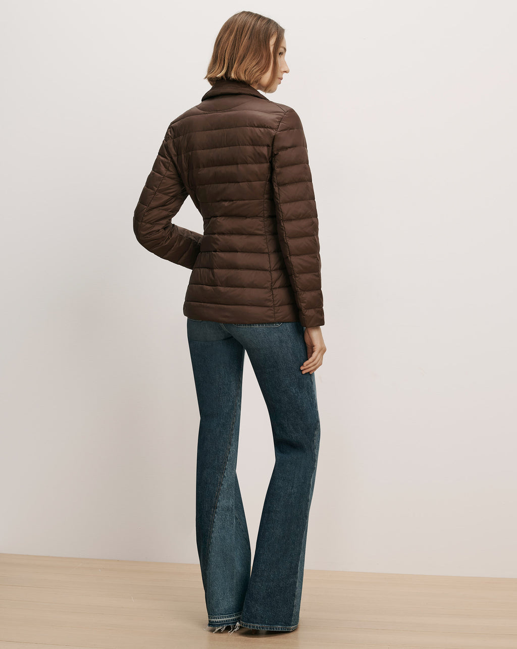 Veronica Beard Brown quilted puffer jacket and blue jeans.