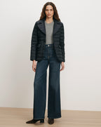 Veronica Beard Black quilted jacket, gray sweater, dark wash wide-leg jeans.