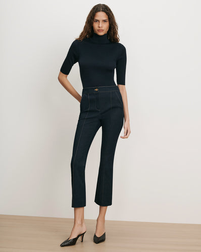 Veronica Beard Black ribbed turtleneck top and dark wash flared jeans.