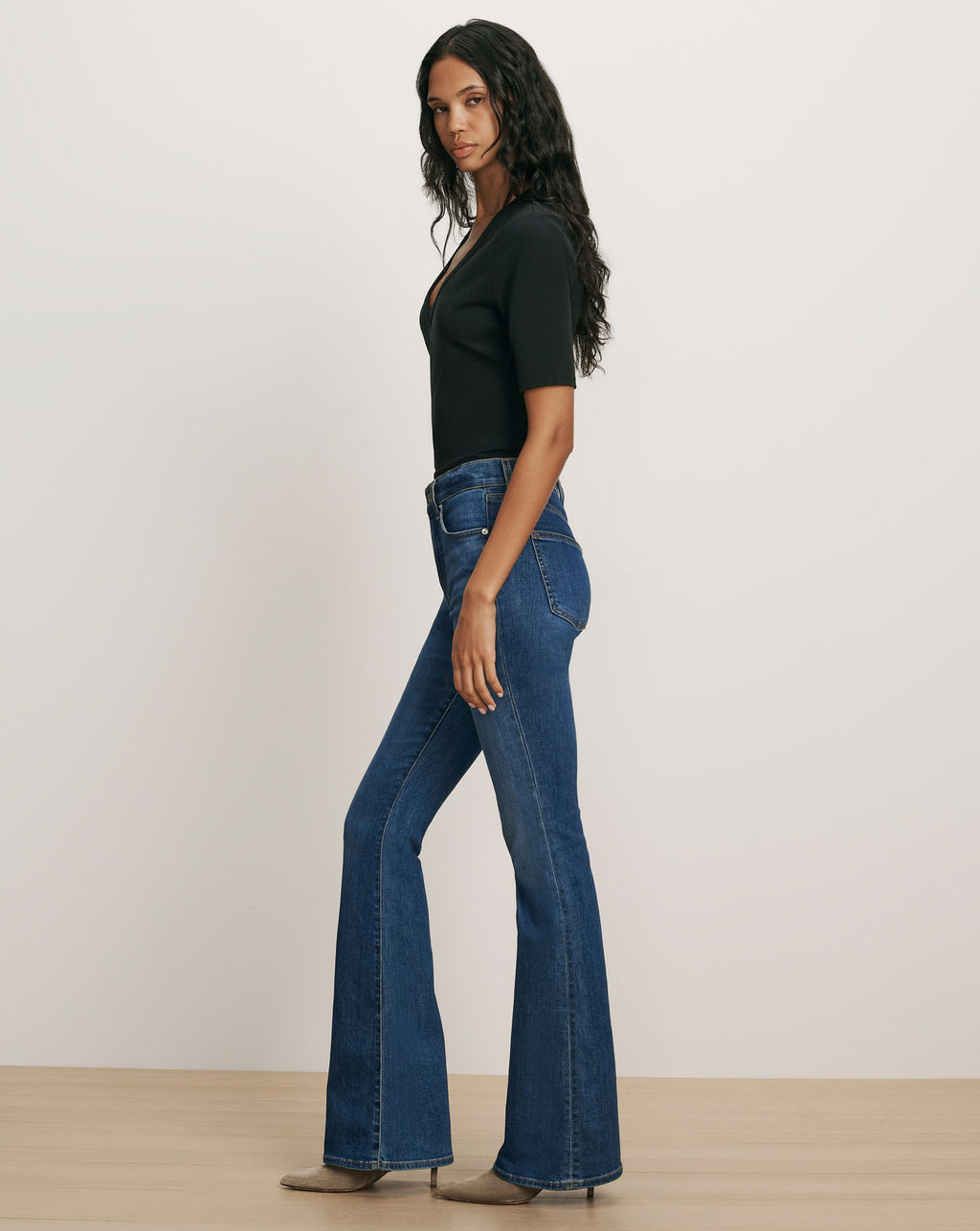 Veronica Beard Black short-sleeve V-neck top and blue flare jeans.
