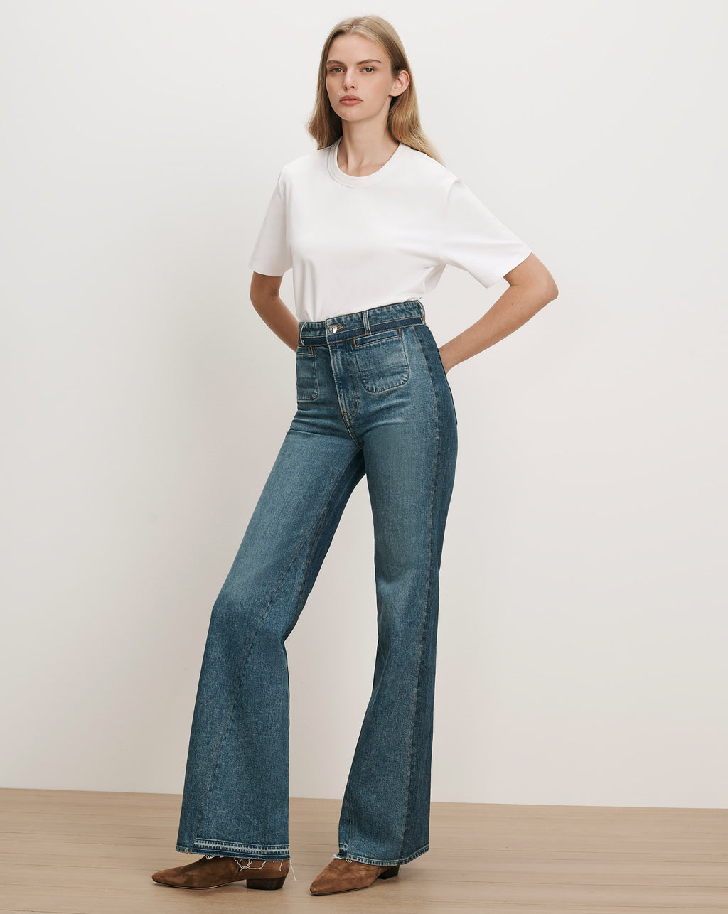Veronica Beard White t-shirt, blue flared jeans with patch pockets.