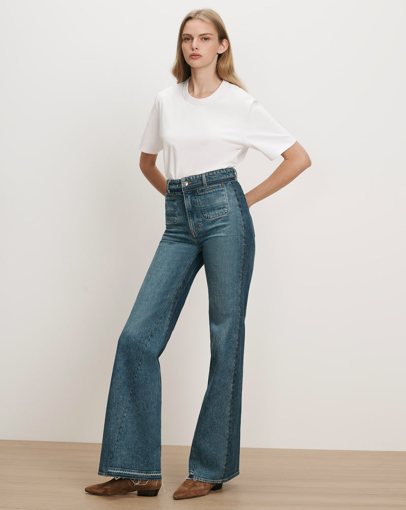 Veronica Beard White t-shirt, blue flared jeans with patch pockets.