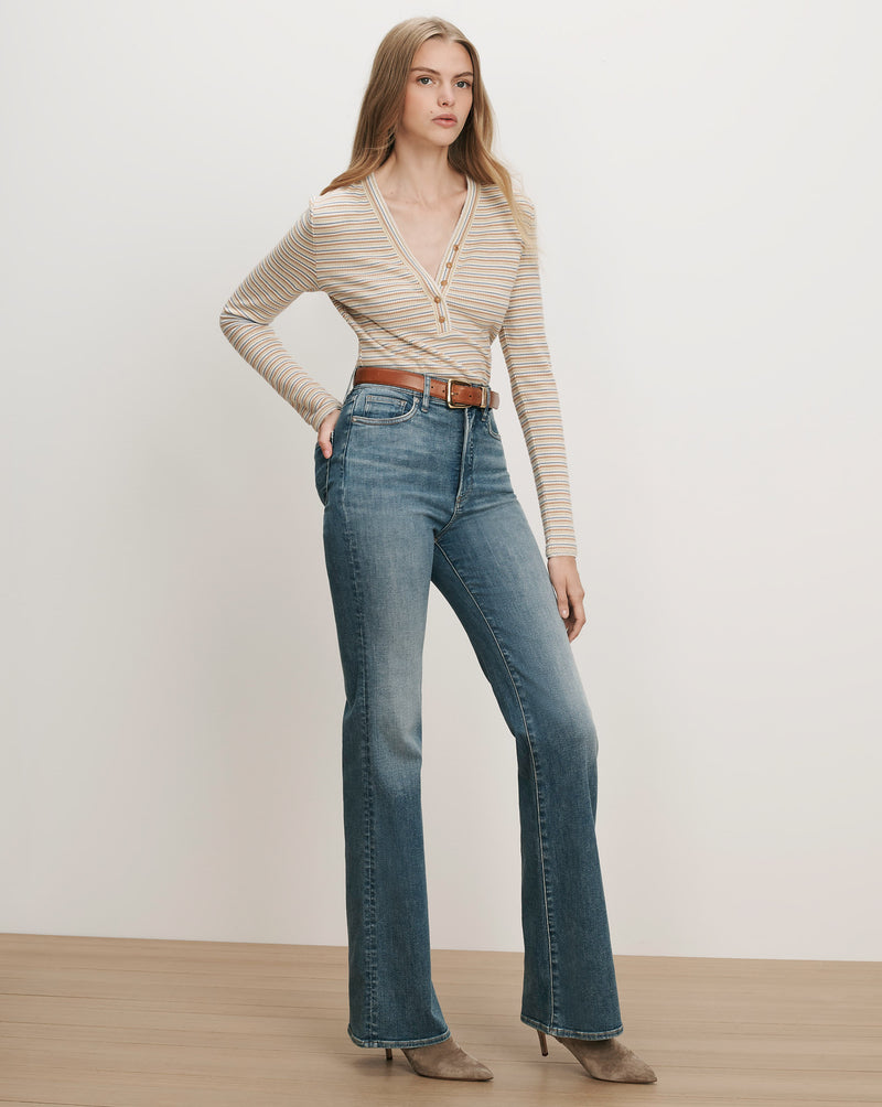 Veronica Beard Striped long-sleeve henley, blue flare jeans, brown belt.