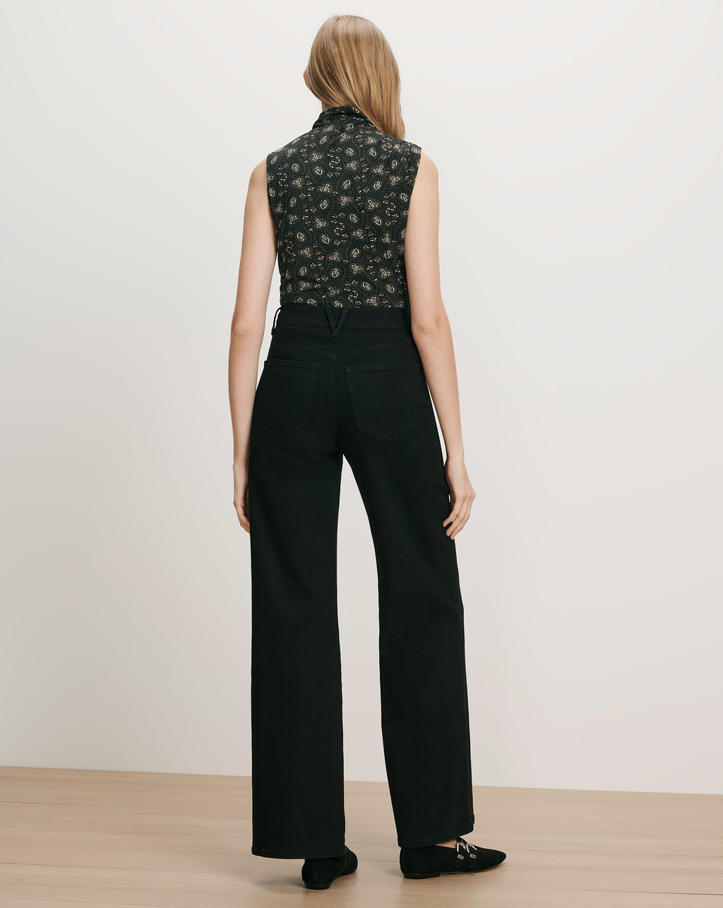 Veronica Beard Black floral sleeveless top and black wide-leg jeans.