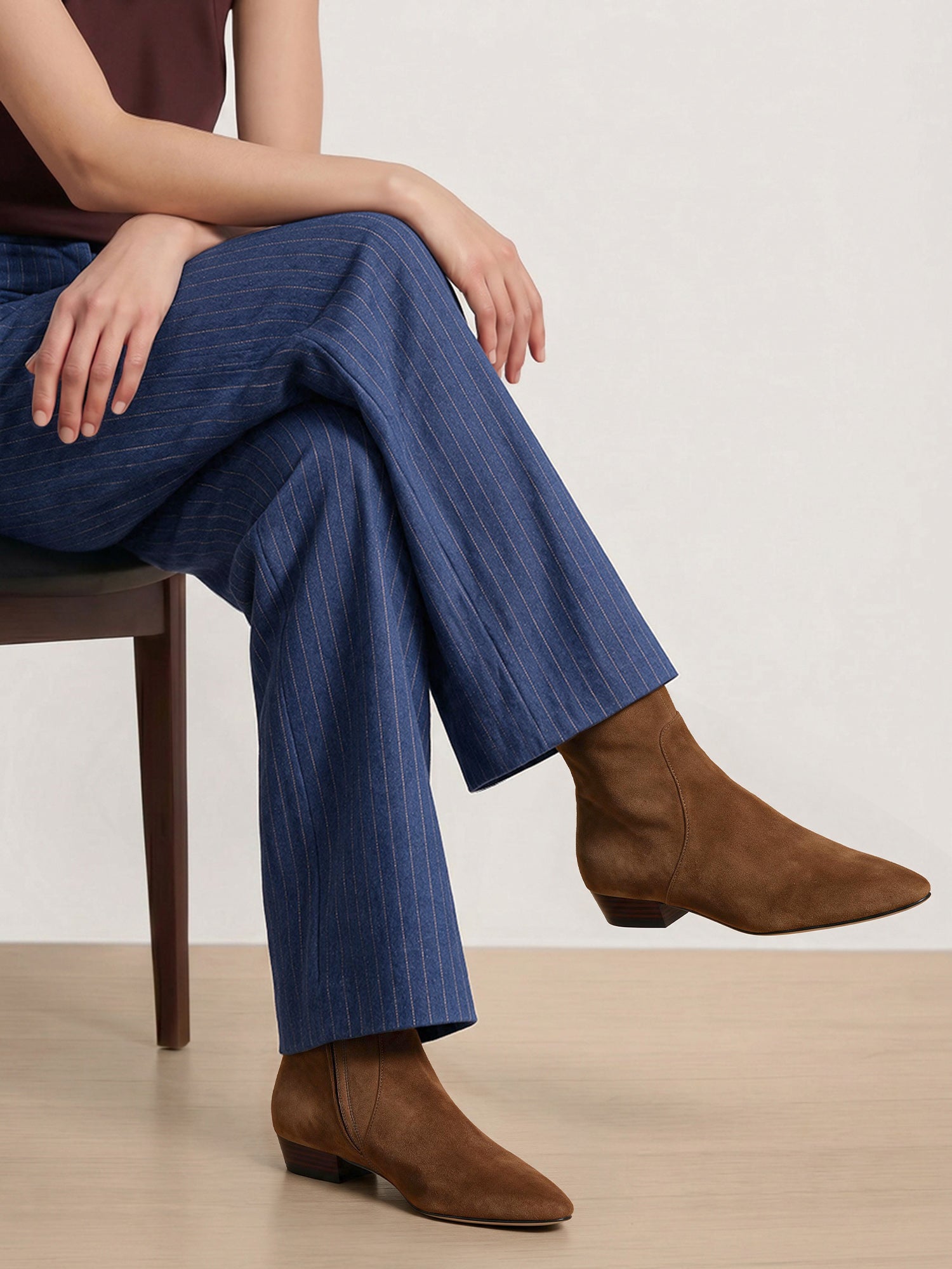 Veronica Beard Blue pinstripe trousers and brown suede boots.