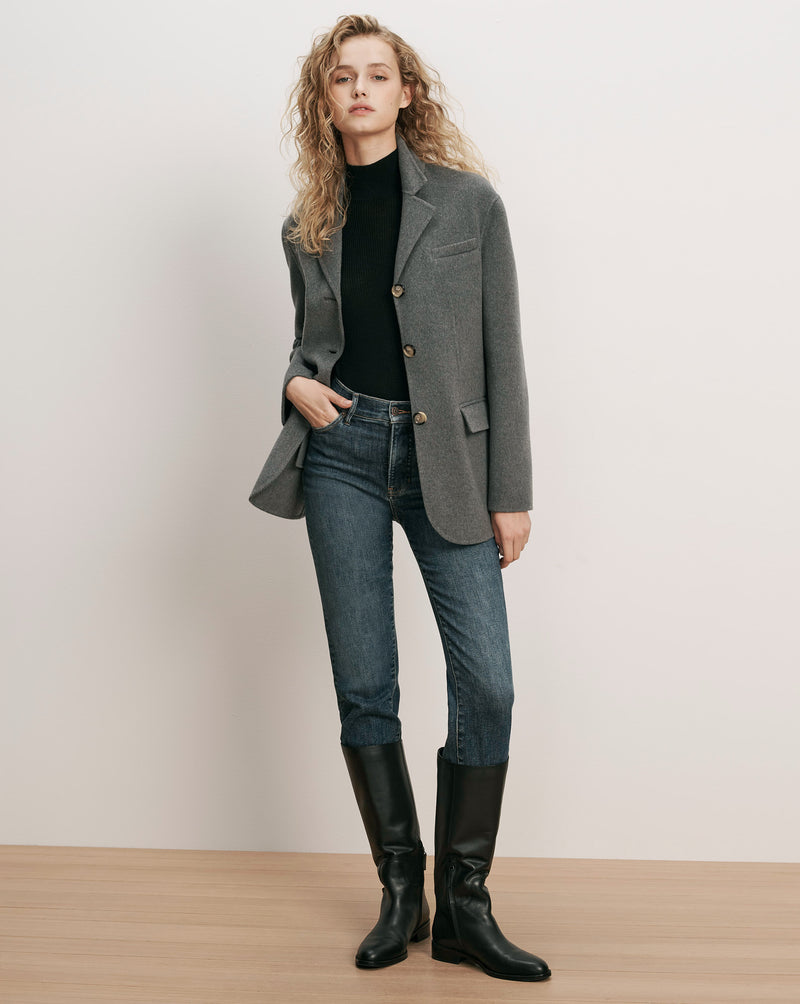 Veronica Beard Gray blazer, black turtleneck, blue jeans, black boots.