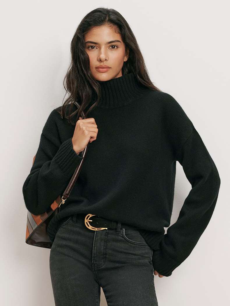 Veronica Beard Black turtleneck sweater, dark wash jeans, black boots.