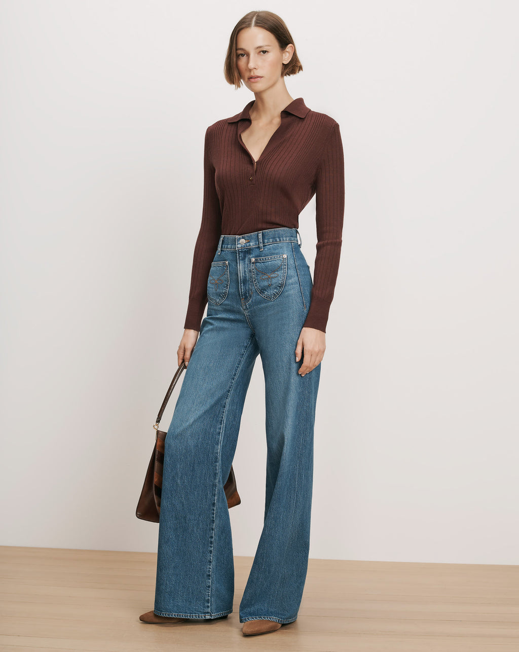 Veronica Beard Brown ribbed knit polo, blue wide-leg jeans.
